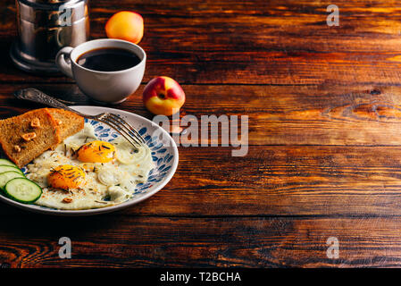 Frühstück Toast mit Spiegelei mit Gemüse auf dem Teller und Tasse Kaffee mit Früchten auf dunklem Hintergrund. Gesunde, saubere Essen, Diäten foo Stockfoto