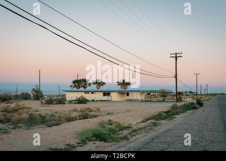 Verlassenes Haus und Straße bei Sonnenuntergang, in Salton City, Kalifornien Stockfoto
