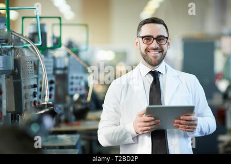 Lächelnd Fabrikarbeiter Holding Tablet Stockfoto