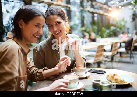 Tratschen über Leute in Cafe Stockfoto