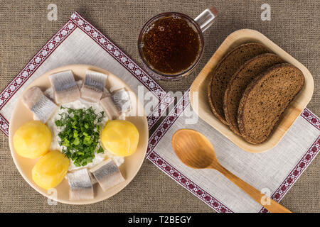 Lettische traditionelles Gericht - Quark mit Pellkartoffeln, leicht gesalzenem Hering und Grüns Stockfoto