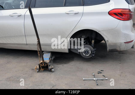 Austausch der Räder auf ein Auto, Jack hält den Körper in der angehobenen Position. Bruch Beseitigung Stockfoto