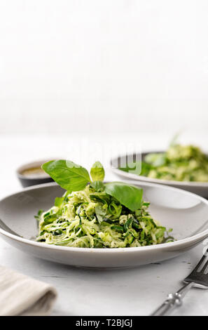 Zucchini vegan Pasta in zwei Platten auf weißem Hintergrund. Vegetarische gesunde Ernährung Konzept Stockfoto