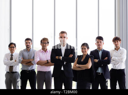 Gruppe zuversichtlich in verschiedenen Vielfalt mit der Waffe in der Corporate Office Einstellung gekreuzt - verschiedenen Rassen, Geschlechter, Alter. Stockfoto