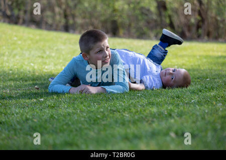 Spielen Brothers das Gras im Sommer Stockfoto