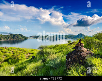 Steine Turm, Rock zen Skulptur in der Natur und Harmonie Landschaft mit grünen Hügeln der Insel Padar im Komodo National Park. Stockfoto