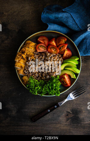 Gesundes Abendessen Konzept mit Bio Buchweizen, gekochtes Ei, Kräutern, Avocado, und Fleisch auf rustikalen Hintergrund Stockfoto