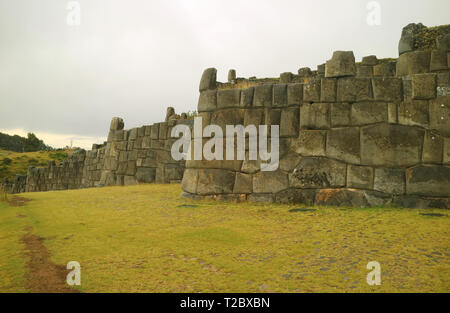 Unglaubliche Inka Stein Mauern der Festung Sacsayhuaman mit Statue des Christus in der Entfernung, Cusco, Peru Stockfoto