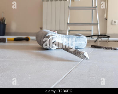 Bohrmaschine und Bohrer für Beton und verschiedene andere Tools auf dem Boden Stockfoto