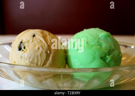 Zwei Kugeln Chocolate Chip und Lime Sherbet Eis in einem Glasgefäß Stockfoto