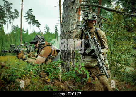 Airsoft Männer mit Gewehren stehen Rücken an Rücken. Soldaten stand auf einem Hügel und auf Abruf Stockfoto