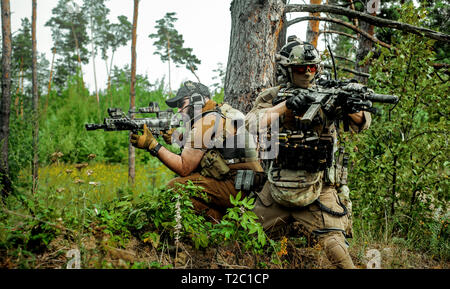 Airsoft Männer mit Gewehren stehen Rücken an Rücken. Soldaten stand auf einem Hügel und auf Abruf Stockfoto