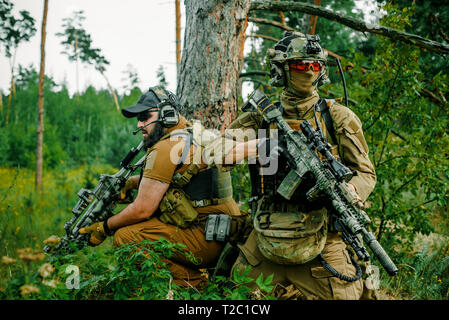 Airsoft Männer mit Gewehren stehen Rücken an Rücken. Soldaten stand auf einem Hügel und auf Abruf Stockfoto