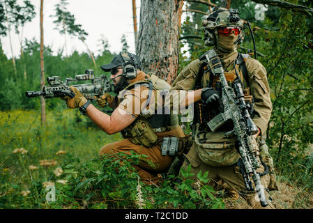 Airsoft Männer mit Gewehren stehen Rücken an Rücken. Soldaten stand auf einem Hügel und auf Abruf Stockfoto