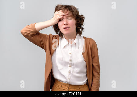 Frustrierte Frau fühlen starke Kopfschmerzen betont. Curly Dame leidet unter schrecklichen Schmerzen Migräne oder Sie vergessen wichtige Informationen. Stockfoto