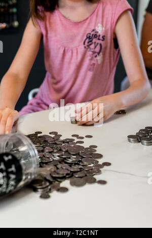 Kleines Mädchen zählen, Geld von ihr Geld box Stockfoto