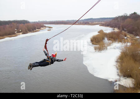 Belarus, Gomel, März 08, 2019. Das Springen von der Brücke zum Seil. Ropejumping. Eine Frau springt aus großer Höhe und fliegen im Himmel auf einem Seil oben Stockfoto