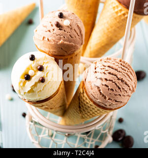 Hausgemachten Kaffee, Vanille und Schokolade Eis in der Waffel Kegel auf Türkisfarbenem Hintergrund. Gesund Sommer essen Konzept. Stockfoto