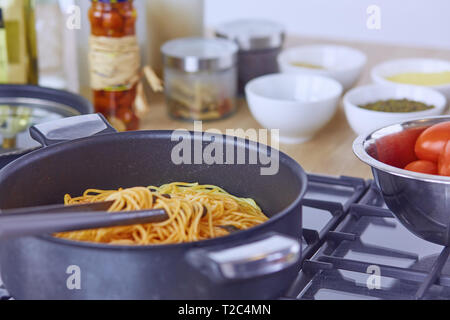 Pasta rollte auf Gabel über Pan am Herd in der Küche. Stockfoto