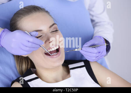 Schöne Mädchen in der zahnmedizinischen Stuhl über die Untersuchung beim Zahnarzt. Stockfoto