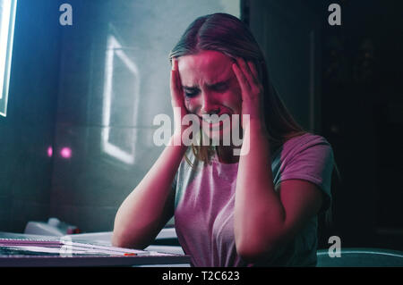 Droge Obsession und Schmerzen. Drogenabhängig hält Hände in die Hand und ist verrückt in der Nähe von Drogen. Allein Droge süchtig Frau mit Verschmiertem Make-up weint in Stockfoto