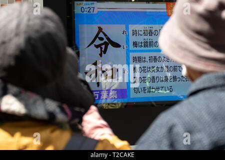 Tokio, Japan. 1 Apr, 2019. Tokio, Japan. 01 Apr, 2019. Leute schauen auf einen Bildschirm, der die Nachrichten der neue Name "Reiwa'' für die nächsten Kaiserzeit, in der Innenstadt von Tokio. Japanische Chief Cabinet Secretary Yoshihide Suga angekündigt ''Reiwa'' als neue Kaiserzeit Name heute, 1. April. Die neue Ära beginnt am 1.Mai, wenn der Kronprinz Naruhito besteigt den Thron, nachdem sein Vater, Kaiser Akihito, formal dankt am 30. April. Credit: Rodrigo Reyes Marin/LBA/Alamy leben Nachrichten Stockfoto