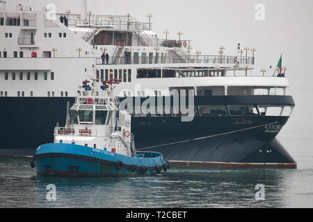 Cobh, Cork, Irland. Der 1. April 2019. Erste liner der neuen Saison Kreuzfahrt Astoria von der Tug Boat Gerry O'Sullivan in Cobh, Co Cork, Irland manövriert wird. Quelle: David Creedon/Alamy leben Nachrichten Stockfoto