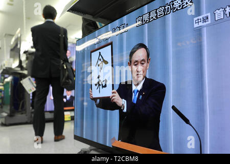 Tokio, Japan. 01 Apr, 2019. Foto aufgenommen am 1. April 2019 zeigt eine TV Sendung über Japan's Chief Cabinet Secretary Yoshihide Suga Holding aloft ein gerahmtes Bild von 'Reiwa', der Name des neuen Japan ära, während einer Pressekonferenz in Tokio, Japan. Die japanische Regierung verkündete Montag, 'Reiwa' wird der Name des neuen Japan Ära werden am 1. Mai, als Kronprinz Naruhito steigt die Chrysantheme Thron die Nachfolge seines Vaters Kaiser Akihito zu starten. Quelle: Xinhua/Alamy leben Nachrichten Stockfoto