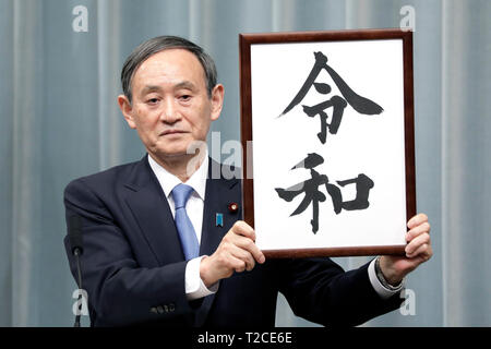 Tokio, Japan. 01 Apr, 2019. Japan's Chief Cabinet Secretary Yoshihide Suga hält aloft ein gerahmtes Bild von 'Reiwa', der Name des neuen Japan ära, während einer Pressekonferenz in Tokyo, Japan, April 1, 2019. Die japanische Regierung verkündete Montag, 'Reiwa' wird der Name des neuen Japan Ära werden am 1. Mai, als Kronprinz Naruhito steigt die Chrysantheme Thron die Nachfolge seines Vaters Kaiser Akihito zu starten. Quelle: Xinhua/Alamy leben Nachrichten Stockfoto