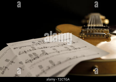 Vintage archtop Gitarre in Ahorn-natur Close-up high Angle View mit Noten auf schwarzem Hintergrund Stockfoto
