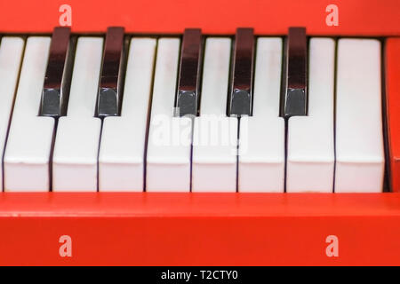 Blick von oben auf die schwarzen und weißen Tasten mit roten Seite. In der Nähe der Tasten. In der Nähe der Vorderansicht. Klavier Keyboard mit selektiven Fokus. Stockfoto