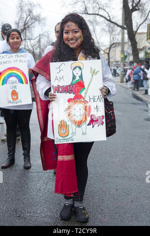 Ein Hindu Frau im Holi Parade marschiert auf Freiheit Ave in Richmond Hill, Queens und Durchführung ein Zeichen über Frauen stolz. Stockfoto