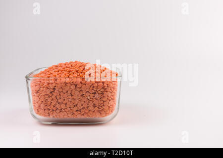 Rote Linsen in der Glasplatte auf weißem Hintergrund Stockfoto