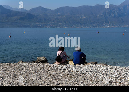 Leute, die am Ufer des Sees Gardasee Italien Stockfoto