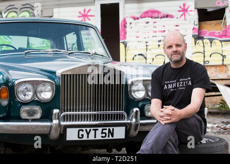 Gavin Turk, Künstler, mit seinem alten Rolls Royce Auto auf Ödland in der Nähe seiner East London Studio fotografiert, Vereinigtes Königreich Stockfoto