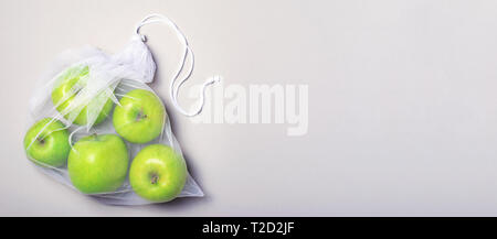 Die Äpfel im Netzbeutel, Null Abfall Konzept, Umweltfreundlich einkaufen Tasche über beigen Hintergrund Stockfoto