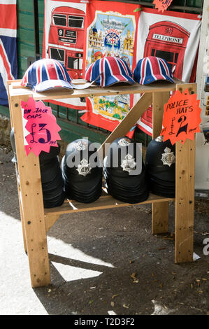 Ein Stall der Hüte, Polizei Helme und Baseball Kappen auf den Verkauf als Souvenirs in Oxford, Großbritannien Stockfoto