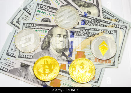 Cryptocurrency Bitcoin, Bindestrich, litecoin, des Astraleums, monerocoins auf einem Haufen hundert Dollar Rechnungen angezeigt. Stockfoto