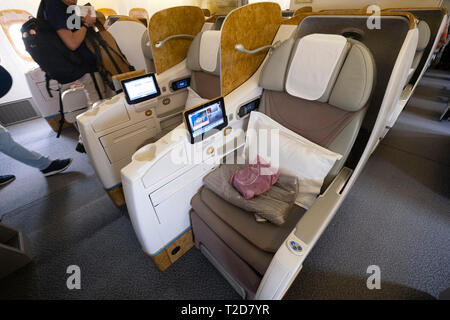 Die geräumigen Business Class leere Sitze mit Kissen auf einem Emirates kommerziellen Flug Flugzeug Stockfoto