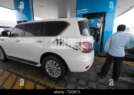 Man füllt sein SUV Kraftstofftank an einer Tankstelle in Dubai, Vereinigte Arabische Emirate Stockfoto