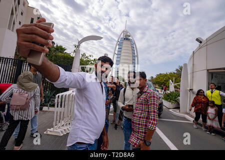 Gruppe von Touristen eine selfie vor dem Burj Al Arab Jumeirah Hotel in Dubai, Vereinigte Arabische Emirate Stockfoto