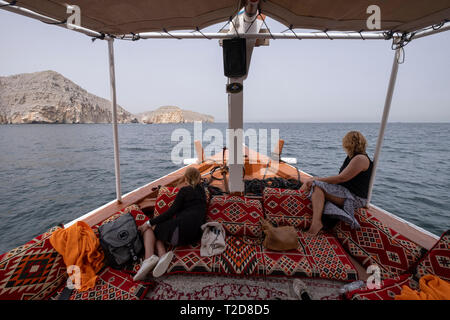 Cruise Tour an Bord eines traditionell eingerichtete arabischen Dhow Boot entlang der Rocky Mountains der Musandam Halbinsel im Oman Fjorde Stockfoto