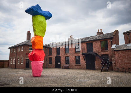 Außerhalb der Kunstgalerie Tate Liverpool durch Gebäude des Royal Albert Dock umgeben steht eine Skulptur von Ugo Rondinone namens Liverpool Berg Stockfoto