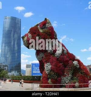Jeff Koons‘ blumenbedeckte Puppy-Skulptur mit der Iberdrola-Turm im Hintergrund, Guggenheim-Museum Bilbao, Baskenland, Spanien Stockfoto
