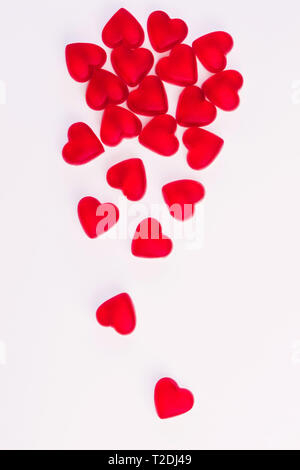 Konzept der fallenden Herzen aus Herzförmige rote Gelee Bonbons auf isolierten weißen Hintergrund. Ansicht von oben. Kopieren Sie Platz. Stockfoto