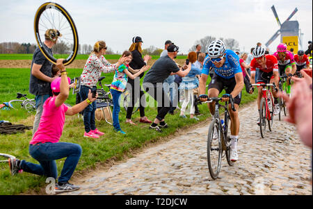 Templeuve, Frankreich - April 08, 2018: Das peloton Reiten auf der gepflasterten Straße in Templeuve vor der traditionellen Vertain Windmühle in Paris - Stockfoto