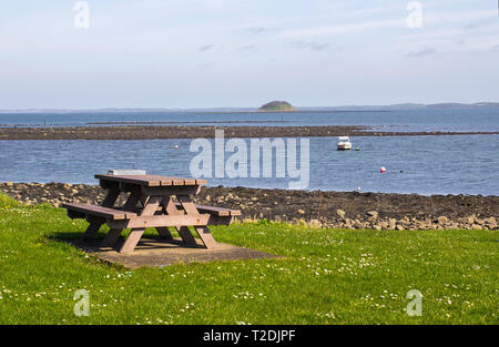28. März 2018 ein Bojen auf dem Meer bei Killyleagh Nordirland mit einem kleinen Picknick Tisch und Rat Abfallbehälter in den Vordergrund. Grüne Gras Stockfoto