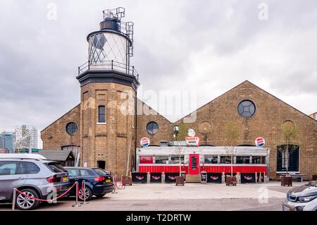 Gelbe Backsteingebäude und Bug Creek Leuchtturm in Trinity Buoy Wharf, East London, Großbritannien Stockfoto