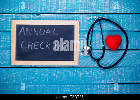 Gesundheit Konzept ein Herz und Stethoskop mit einem schwarzen Brett lesen jährlichen Check-up Stockfoto