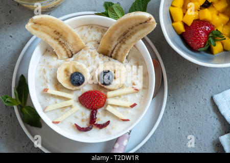 Lustige Schüsseln mit Haferflockenbrei mit Häschen, Küken und Blume für Ostern Stockfoto